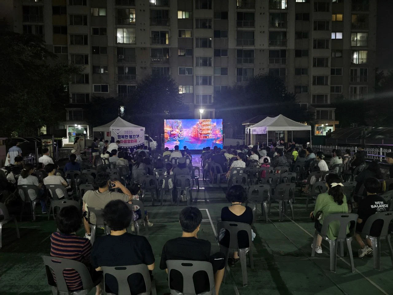 이문쌍용아파트 야외 공간에서 영화를 함께 보는 주민들